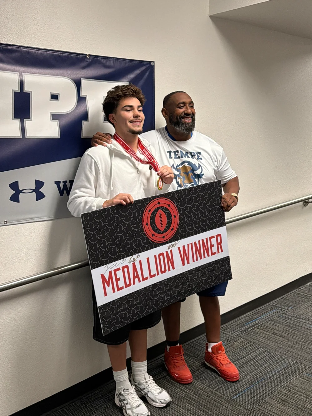 Jaiden Hart-Rodriguez holding his Ed Doherty Award medallion and Medallion Winner sign at Tempe High School